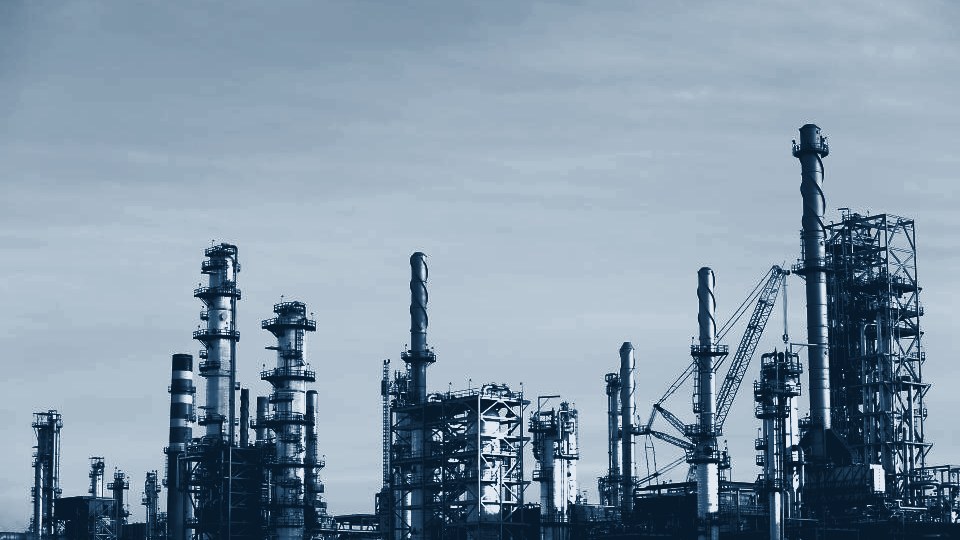 Planta industrial vista desde afuera, torres y estructuras metálicas en tono azul
