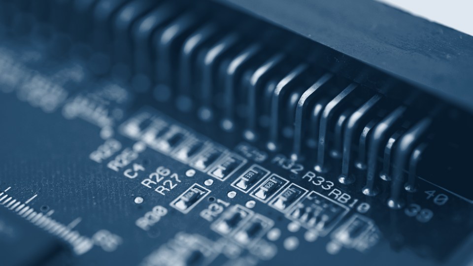 Macro de una tarjeta electrónica con conector y componentes en tono azul